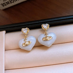 Close-up detail of the sparkling zircons and plating on the pink heart earrings