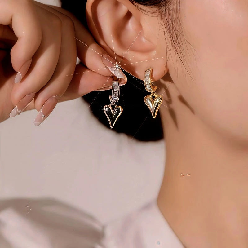 Model showcasing the dangle and style of the 14K Gold-Plated Elegant Zircon Heart Earrings