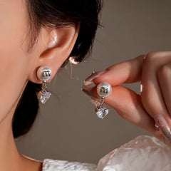 Model showcasing the dangle and style of the 14K Gold-Plated Elegant Zircon Heart Pearl Earrings