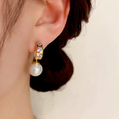 Model showcasing the dangle and style of the 14K Gold-Plated Elegant Zircon Heart Pearl Earrings