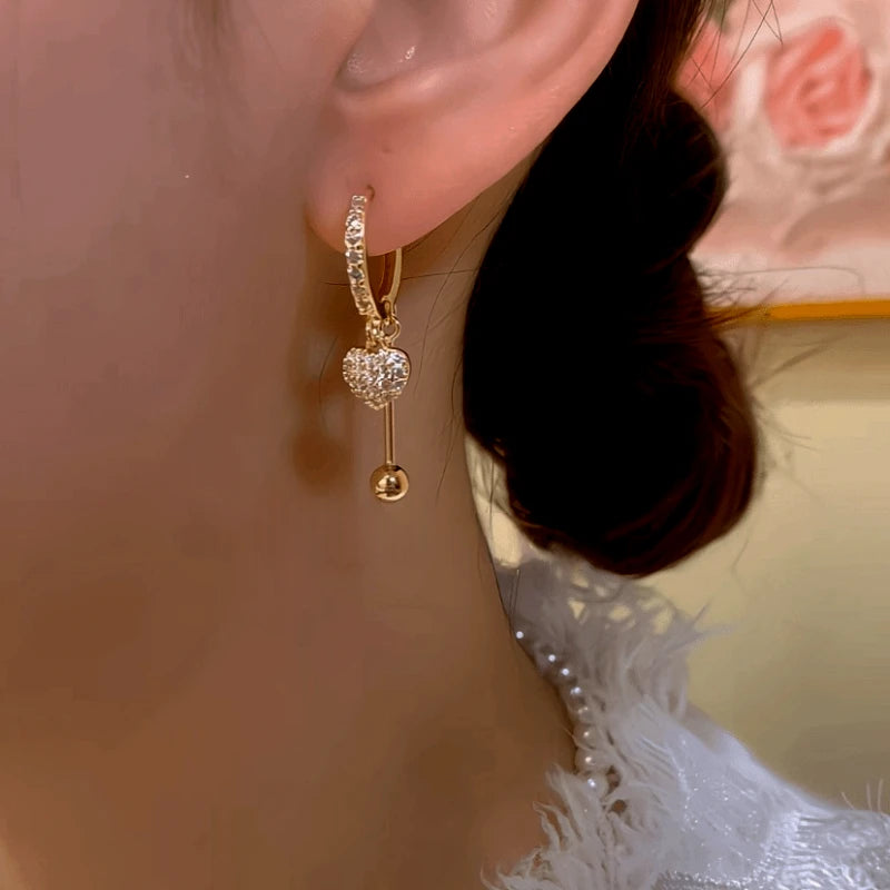 Model showcasing the dangle and style of the 14K Gold-Plated Elegant Zircon Heart Tassel Earrings