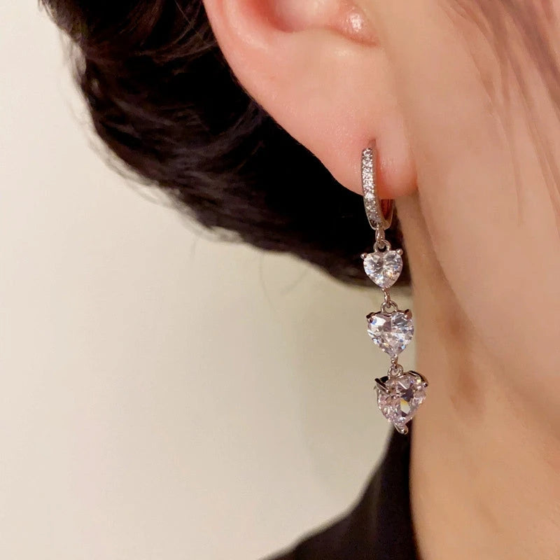 Model showcasing the dangle and style of the 14K Gold-Plated Elegant Zircon Heart Tassel Earrings