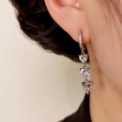 Model showcasing the dangle and style of the 14K Gold-Plated Elegant Zircon Heart Tassel Earrings