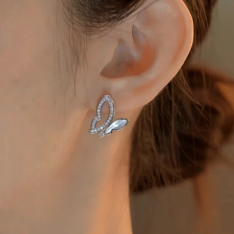 Model showcasing the dangle and style of the 14K Gold-Plated Elegant Zircon Hollow Butterfly Stud Earrings