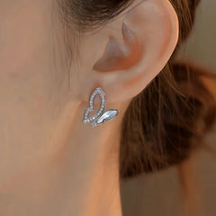 Model showcasing the dangle and style of the 14K Gold-Plated Elegant Zircon Hollow Butterfly Stud Earrings