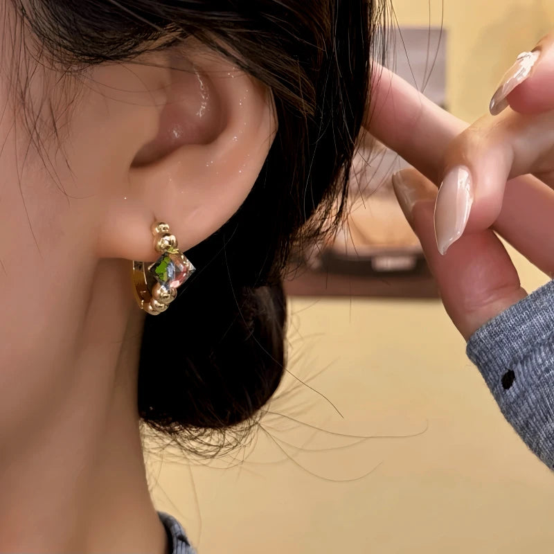 Close-up detail of the sparkling zircons and plating on the gold hoop earrings
