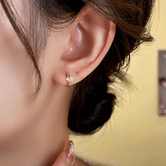 Close-up detail of the sparkling zircons and plating on the gold hoop earrings