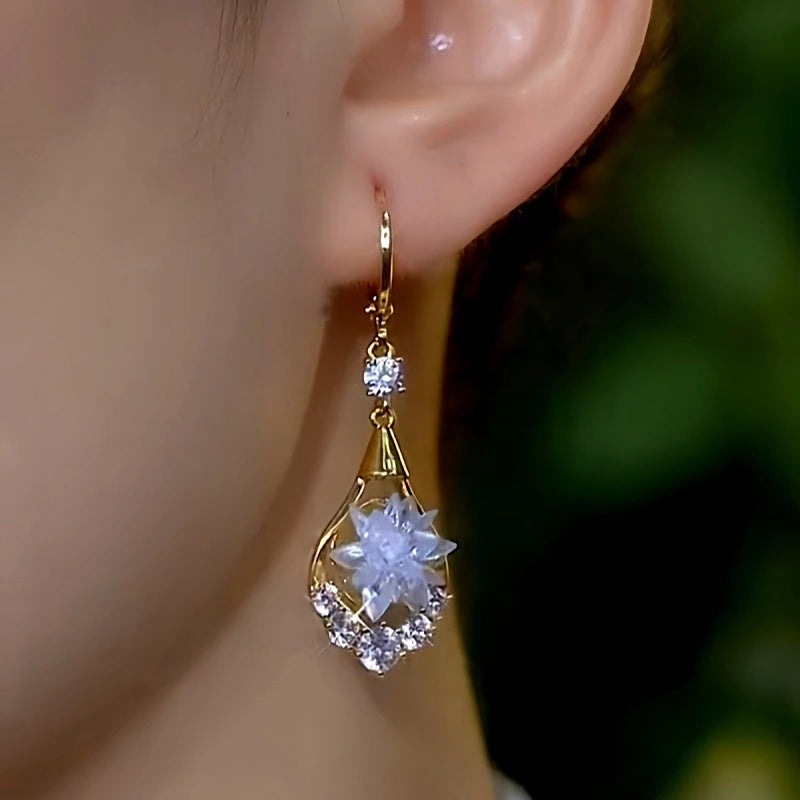 Model showcasing the dangle and style of the 14K Gold-Plated Elegant Zircon Ice-Flower Earrings