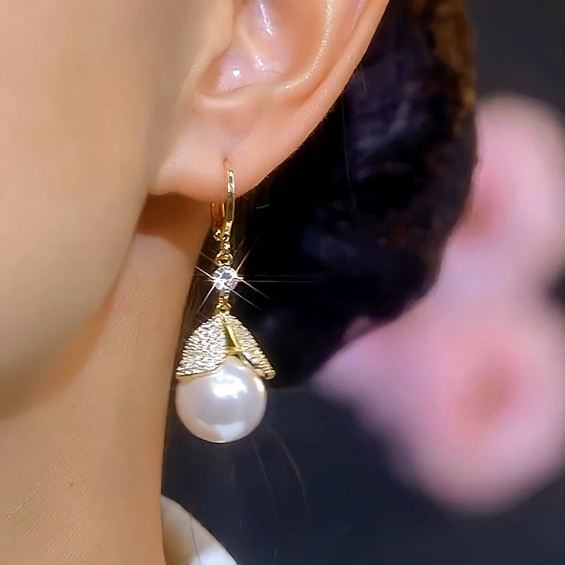 Model showcasing the dangle and style of the 14K Gold-Plated Elegant Zircon Inlaid White Pearl Leaf Earrings