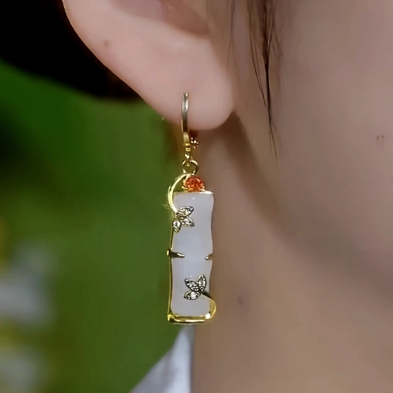 Model showcasing the dangle and style of the 14K Gold-Plated Elegant Zircon Jade Bamboo Earrings