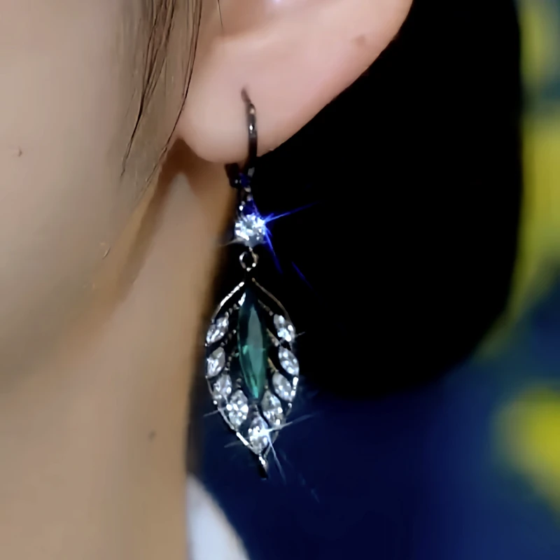 Model showcasing the dangle and style of the 14K Gold-Plated Elegant Zircon Jade Leaf Earrings