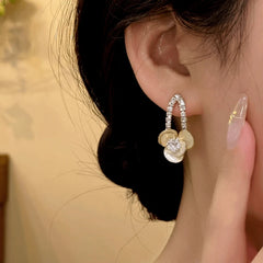 Close-up detail of the sparkling zircons and plating on the gold flower earrings