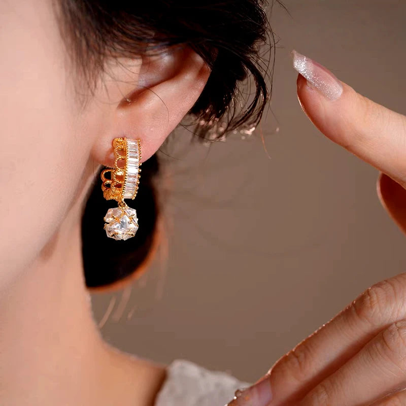 Model showcasing the dangle and style of the 14K Gold-Plated Elegant Zircon Lace Ball Earrings