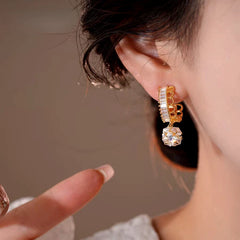 Close-up detail of the sparkling zircons and plating on the gold drop earrings