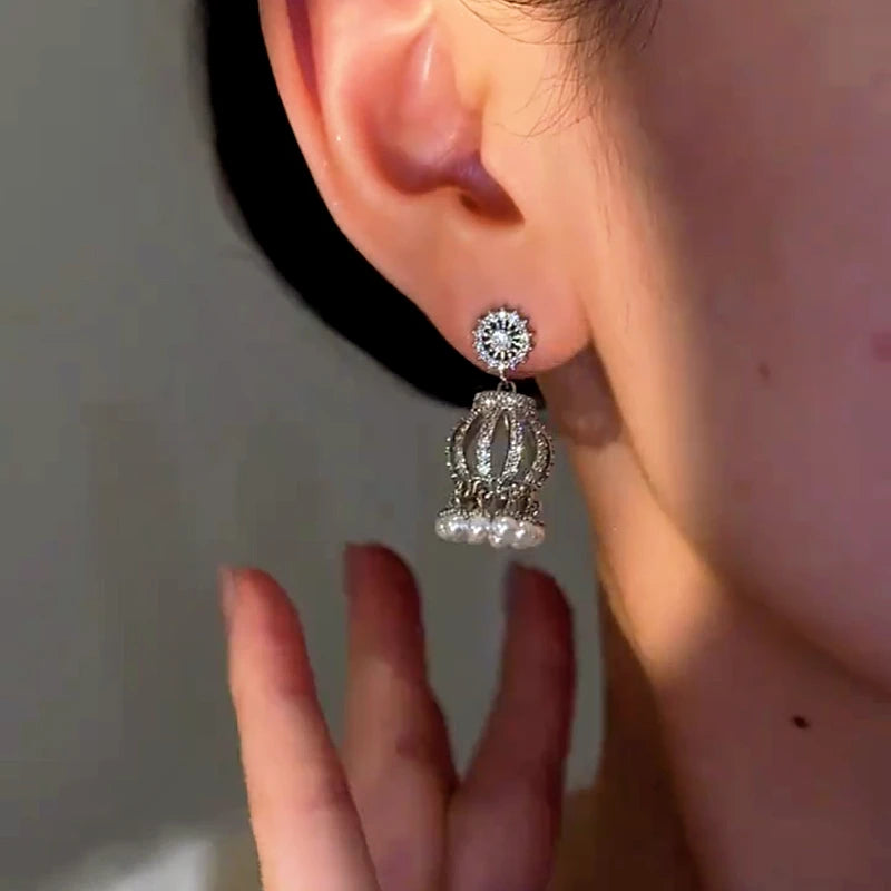 Model showcasing the dangle and style of the 14K Gold-Plated Elegant Zircon Lantern Pearl Tassel Earrings