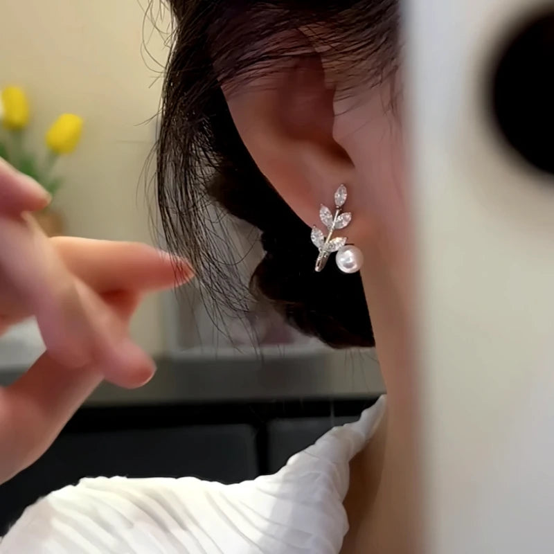 Model showcasing the dangle and style of the 14K Gold-Plated Elegant Zircon Leaf Bead Earrings