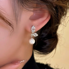 Model showcasing the dangle and style of the 14K Gold-Plated Elegant Zircon Leaf Bead Earrings
