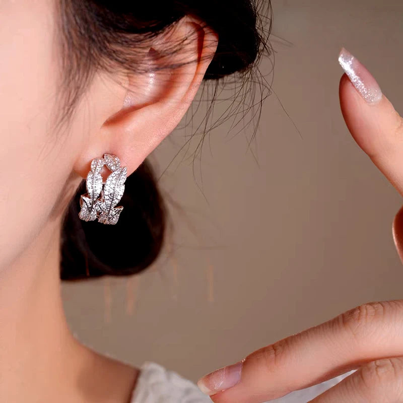 Close-up detail of the sparkling zircons and plating on the silver leaf earrings