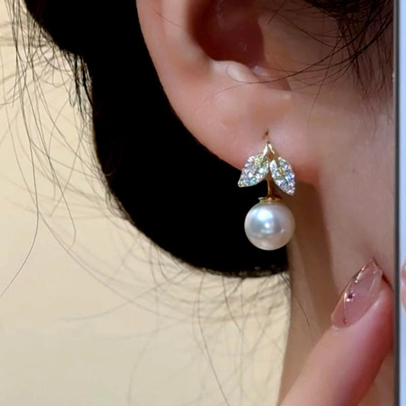 Close-up detail of the sparkling zircons and plating on the gold pearl earrings