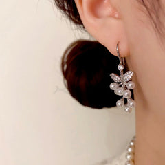 Model showcasing the dangle and style of the 14K Gold-Plated Elegant Zircon Leaf Pearl Ear Hooks