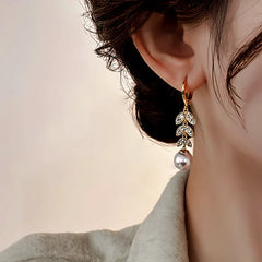 Close-up detail of the sparkling zircons and plating on the gold tassel earrings