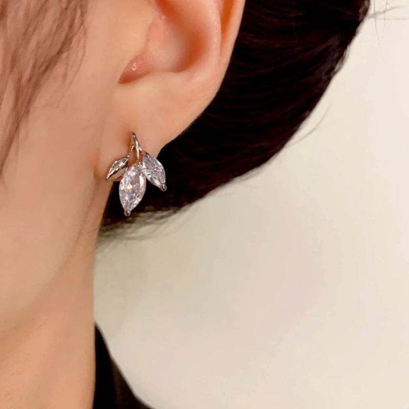 Close-up detail of the sparkling zircons and plating on the gold leaf earrings