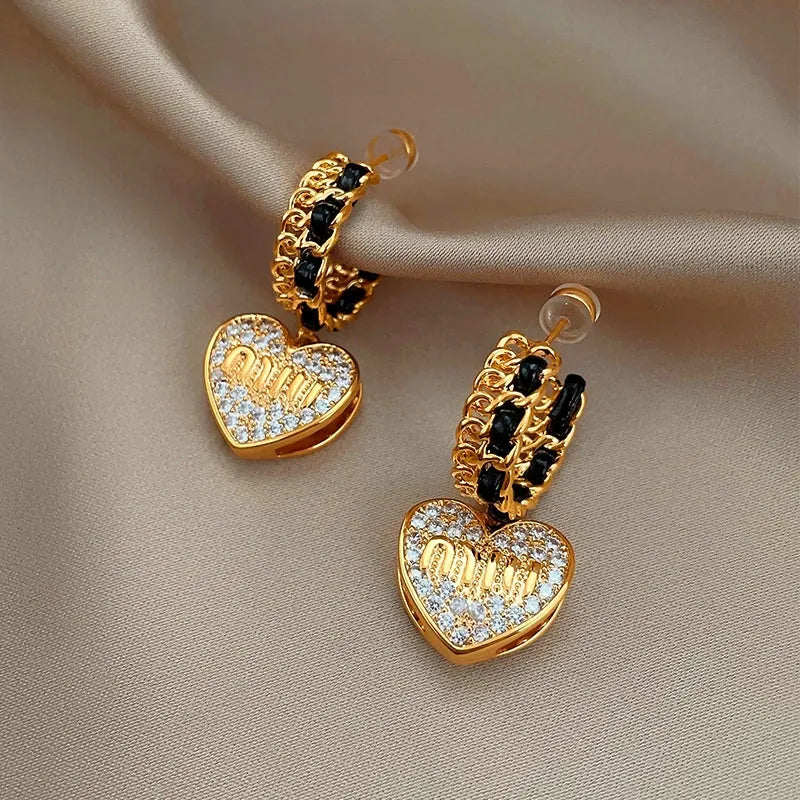 Close-up detail of the sparkling zircons and plating on the gold heart earrings