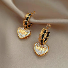 Close-up detail of the sparkling zircons and plating on the gold heart earrings
