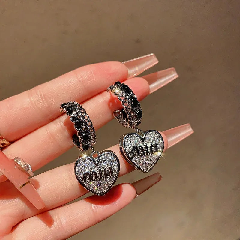 Model showcasing the dangle and style of the 14K Gold-Plated Elegant Zircon Letter Heart Earrings