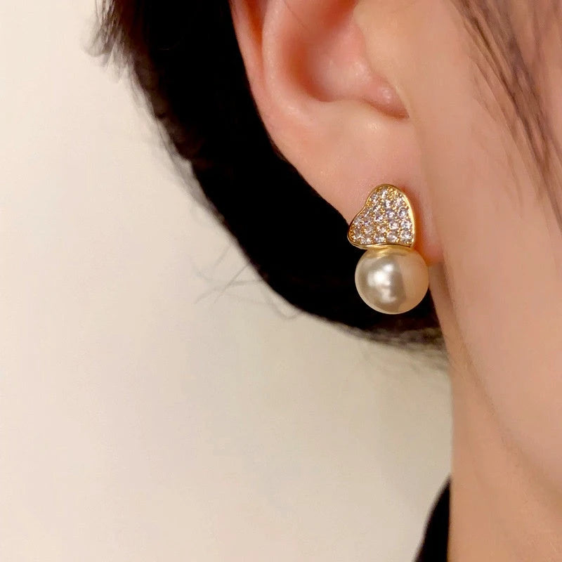 Model showcasing the dangle and style of the 14K Gold-Plated Elegant Zircon Love Pearl Earrings
