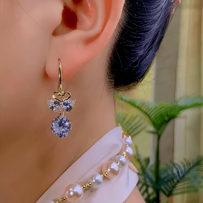Model showcasing the dangle and style of the 14K Gold-Plated Elegant Zircon Mandarin Duck Ear Hooks