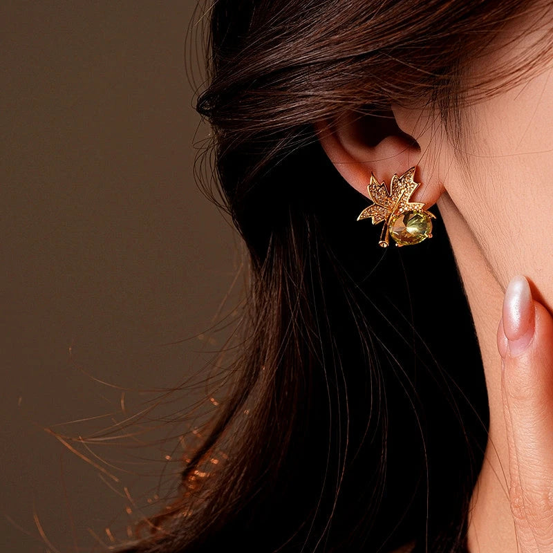 Model showcasing the dangle and style of the 14K Gold-Plated Elegant Zircon Maple Leaf Diamond Stud Earrings
