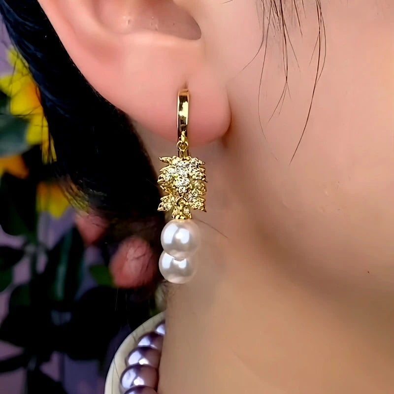 Model showcasing the dangle and style of the 14K Gold-Plated Elegant Zircon Maple Leaf Pearl Tassel Earrings