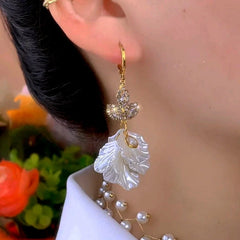 Model showcasing the dangle and style of the 14K Gold-Plated Elegant Zircon Maple Leaf Petal Earrings