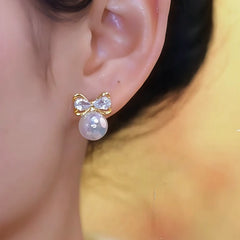 Model showcasing the dangle and style of the 14K Gold-Plated Elegant Zircon Mermaid Bow Pearl Earrings