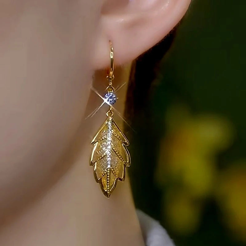 Model showcasing the dangle and style of the 14K Gold-Plated Elegant Zircon Mesh Leaf Earrings