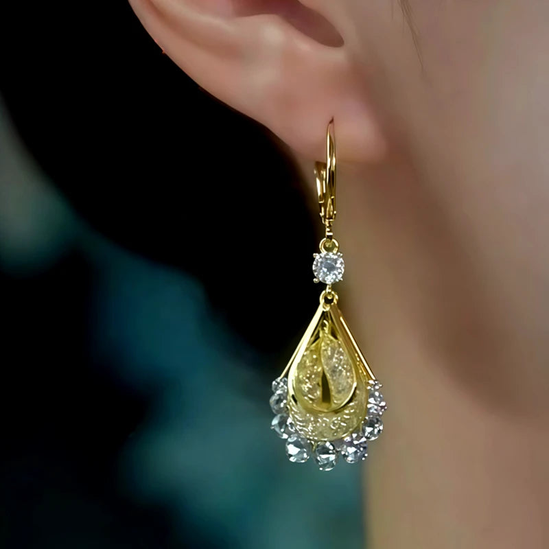 Close-up detail of the sparkling zircons and plating on the gold drop earrings