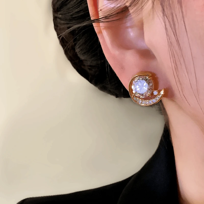 Close-up detail of the sparkling zircons and plating on the gold moon earrings