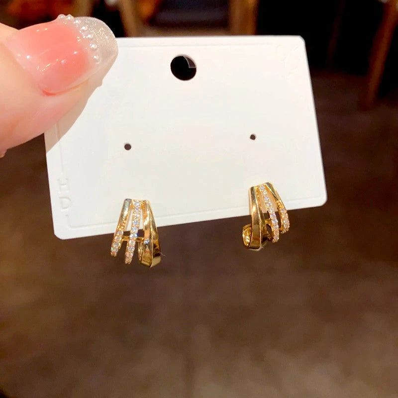 Close-up detail of the sparkling zircons and plating on the gold hoop earrings