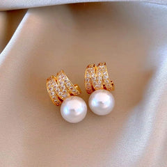 Close-up detail of the sparkling zircons and plating on the gold pearl earrings