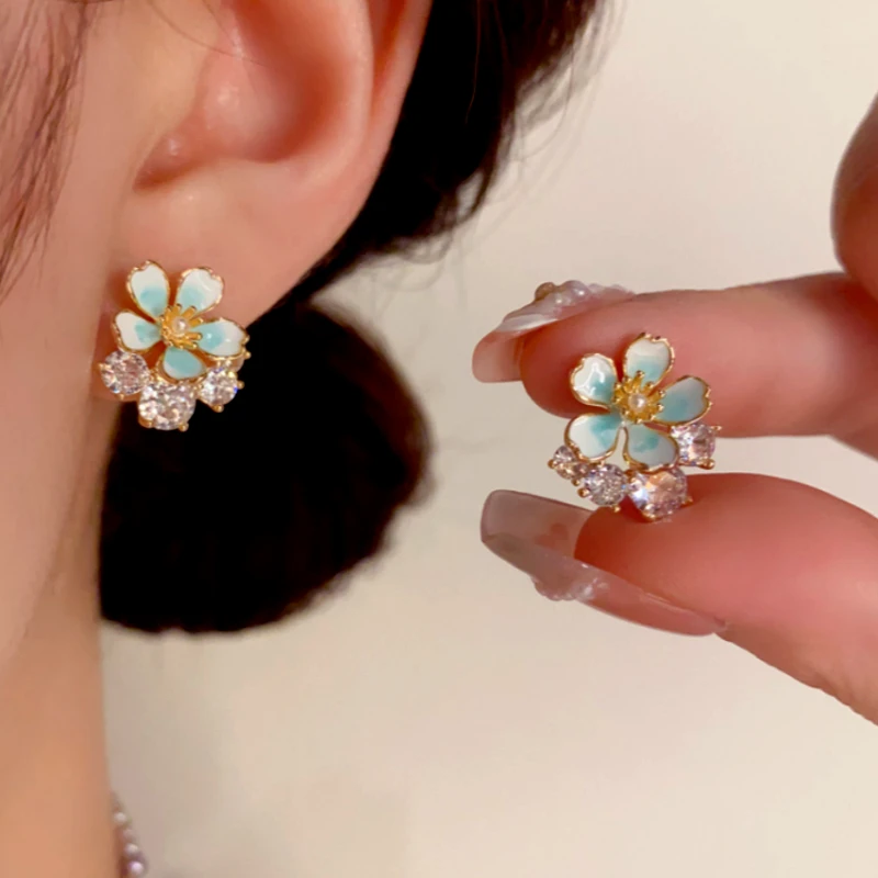 Model showcasing the dangle and style of the 14K Gold-Plated Elegant Zircon Oil Drop Flower Stud Earrings