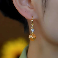 Close-up detail of the sparkling zircons and plating on the gold drop earrings