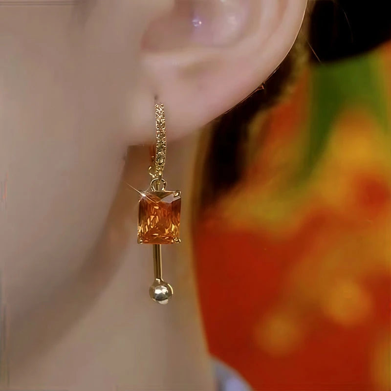 Close-up detail of the sparkling zircons and plating on the gold drop earrings