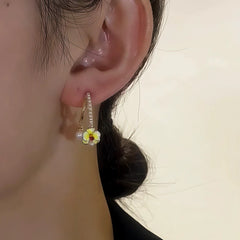 Close-up detail of the sparkling zircons and plating on the gold flower earrings