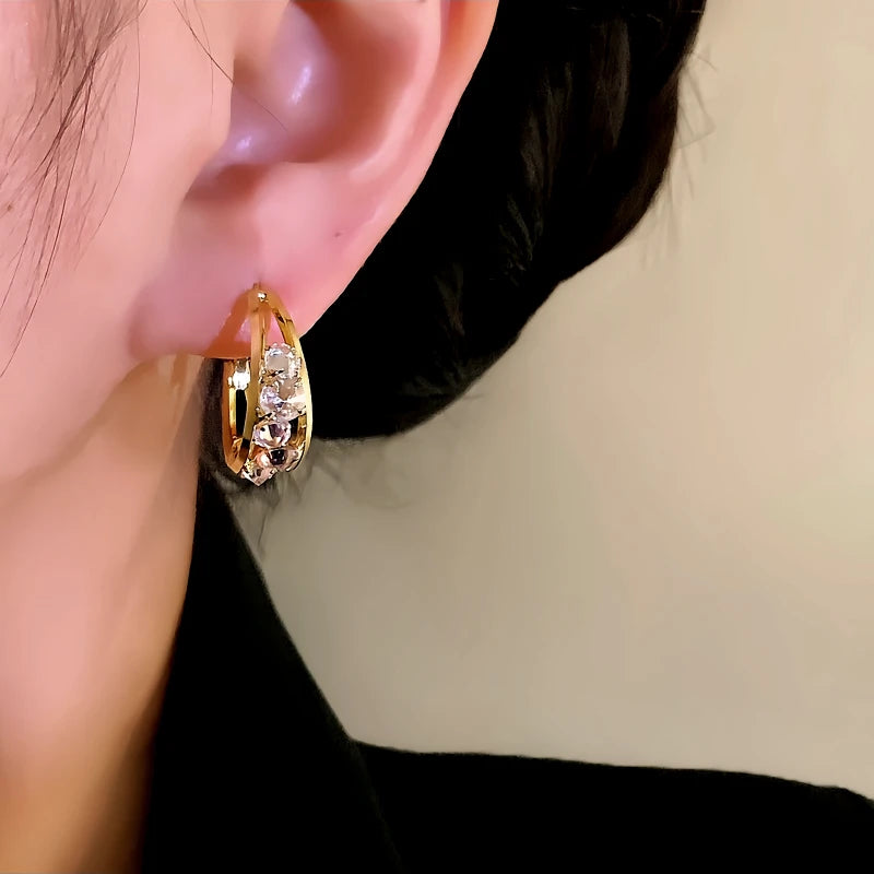 Model showcasing the dangle and style of the 14K Gold-Plated Elegant Zircon Oval Hoop Earrings
