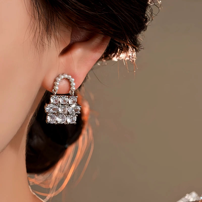 Model showcasing the dangle and style of the 14K Gold-Plated Elegant Zircon Pearl Bag Earrings