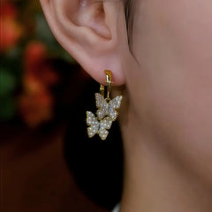 Close-up detail of the sparkling zircons and plating on the gold butterfly earrings