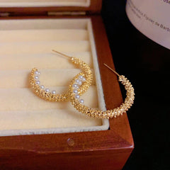 Close-up detail of the sparkling zircons and plating on the gold hoop earrings
