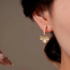 Model showcasing the dangle and style of the 14K Gold-Plated Elegant Zircon Pearl Cat's Eye Flower Earrings