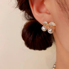 Model showcasing the dangle and style of the 14K Gold-Plated Elegant Zircon Pearl Cherry Earrings